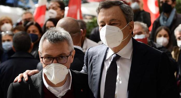 Italian Prime Minister, Mario Draghi (R), is welcomed by the General Secretary of the national trade union Italian General Confederation of Labour (CGIL - Confederazione Generale Italiana del Lavoro) Maurizio Landini (L), upon his arrival at the union headquarters, in Rome, on October 11, 2021 as a gesture of solidarity towards the CGIL following the assault on their headquarters two days ago. - Hundreds of people gathered to demonstrate against anti-coronavirus measures in central Rome, on October 9, 2021, clashing with police and wrecking premises including the headquarters of the CGIL trade union federation. "The people behind the assault on CGIL's headquarters were quickly arrested. They had been stoking tension and violence for too long," said MP Federico Fornaro. (Photo by Filippo MONTEFORTE / AFP)